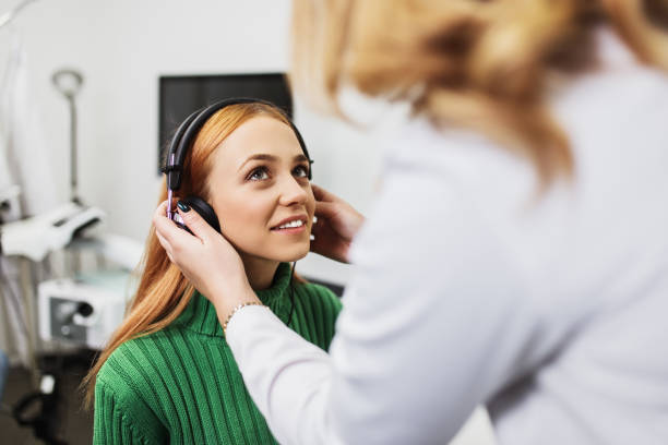 Medical hearing examination Young adult redhead woman at medical examination or checkup in otolaryngologist's office acoustic music photos stock pictures, royalty-free photos & images