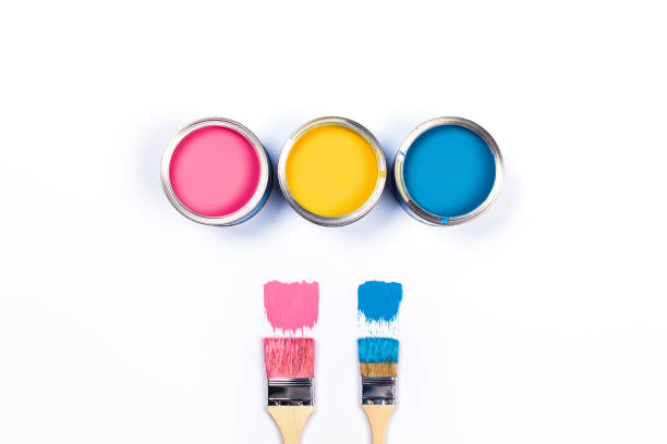 istock White background with three colored paint jars and brushes. 1194695534