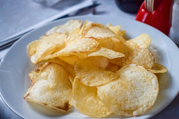 istock White plate with delicious golden potato chips 1194695856
