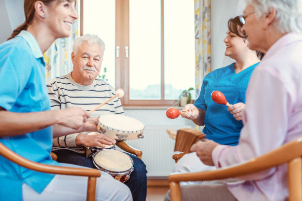 Seniors in nursing home making music with rhythm instruments stock photo