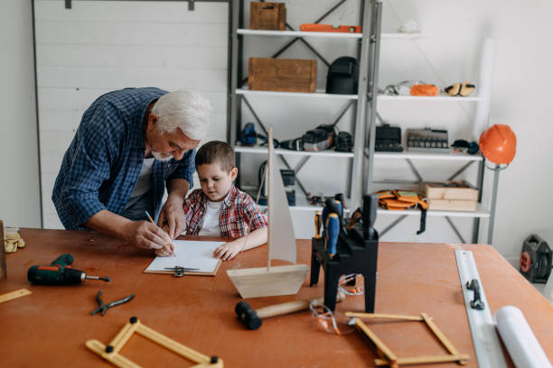 istock Grandfather and grandson building a ship 1194697944