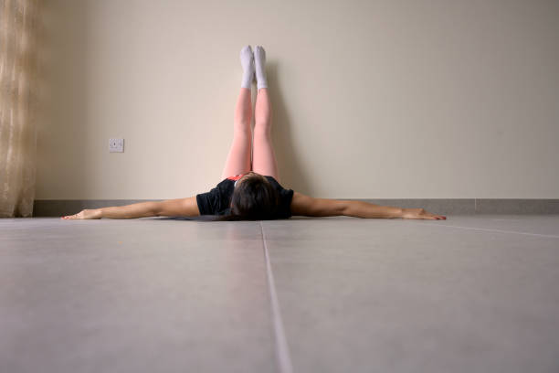 istock woman lying on floor feet up on wall 1194699117