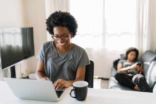 istock Young and beautiful black woman using laptop at home 1194700923