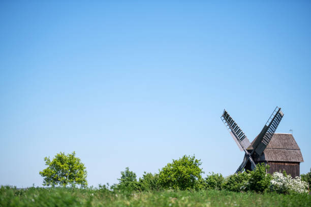 Germany: Historical mill behind green hill on sunny day.