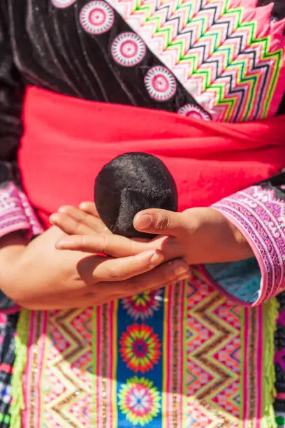Close-up of Hmong tribal girl's hands holding weave cotton rope ball while playing a ball-throwing game in Hmong New Year's celebration in North Thailand.
