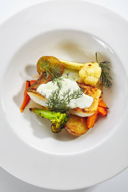 istock Cod Fillet with Baked Vegetables on White Restaurant Plate Isolated 1194703528