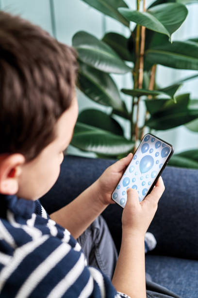 istock 6-7 years child holding and touching smart phone. Smart phone screen with clipping path. 1194704530