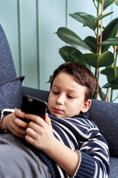 istock 6-7 years child holding and touching smart phone. 1194704582