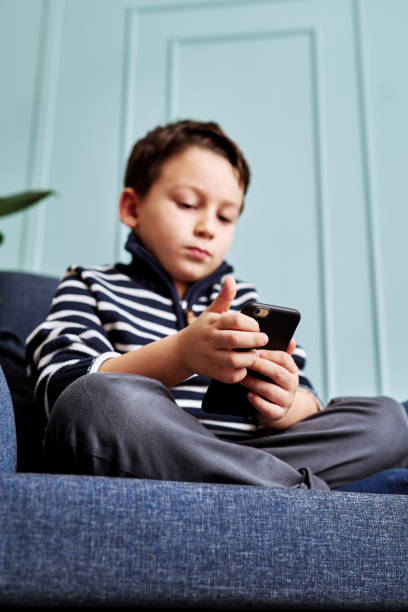 istock 6-7 years child holding and touching smart phone. 1194704947