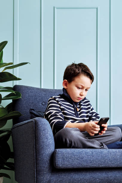 istock 6-7 years child holding and touching smart phone. 1194705810