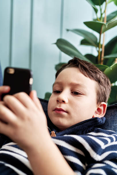 istock 6-7 years child holding and touching smart phone. 1194706422
