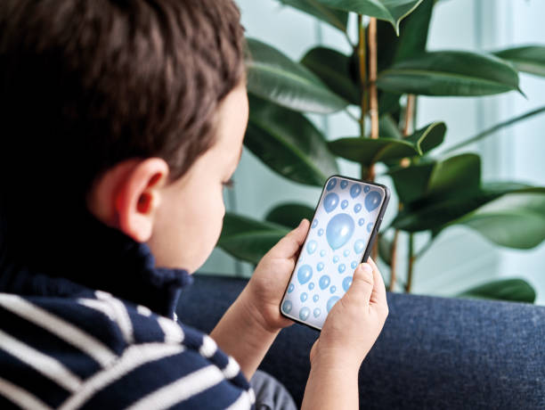 istock 6-7 years child holding and touching smart phone. Smart phone screen with clipping path. 1194706645