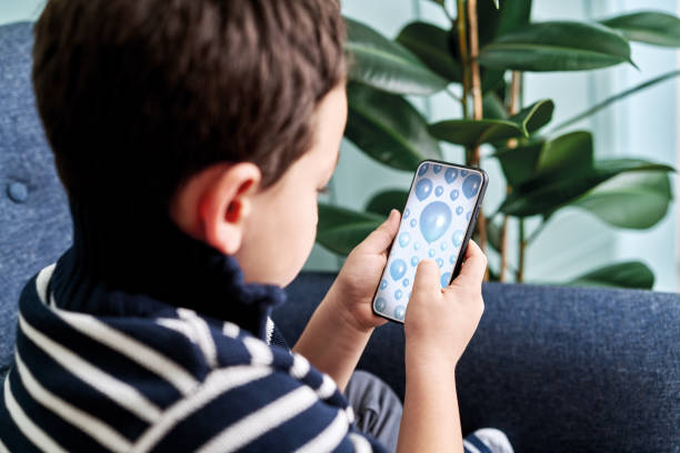 istock 6-7 years child holding and touching smart phone. Smart phone screen with clipping path. 1194707363