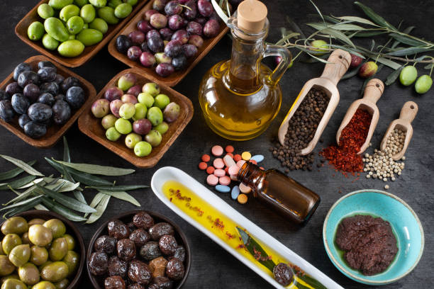 tipi misti di oliva nelle ciotole e olio extravergine di oliva in tavola - cooking oil olive oil nutritional supplement spoon foto e immagini stock
