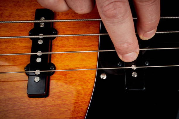 istock Man's hand playing the strings of a bass 1194710009