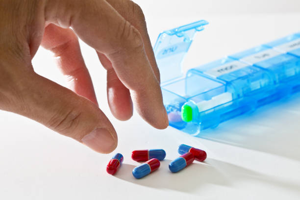 istock Medication Pill Box and Hand Reaching for Prescription Medication 1194711163