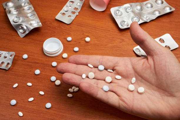 istock Hand picks up pill from a group of pills 1194712256