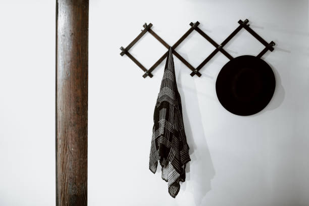 istock Vintage coat rack with black hat and wrap hanging on it. 1194712284