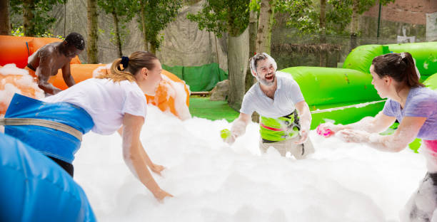 istock Adults collecting balls in inflatable pool with foam 1194712476