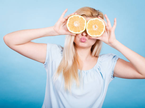 istock Girl covering her eyes with grapefruits 1194712655