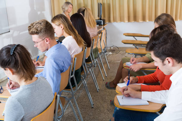istock Students with female teacher on exam 1194713377