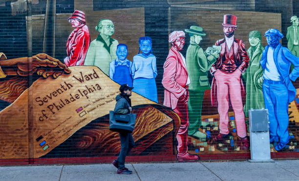 um homem que anda traçando a pintura mural da coragem do mapeamento na rua sul em filadélfia, pensilvânia - philadelphia pennsylvania sidewalk street - fotografias e filmes do acervo