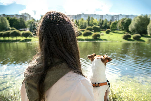 istock girl with a dog in her hands is standing back view 1194717202