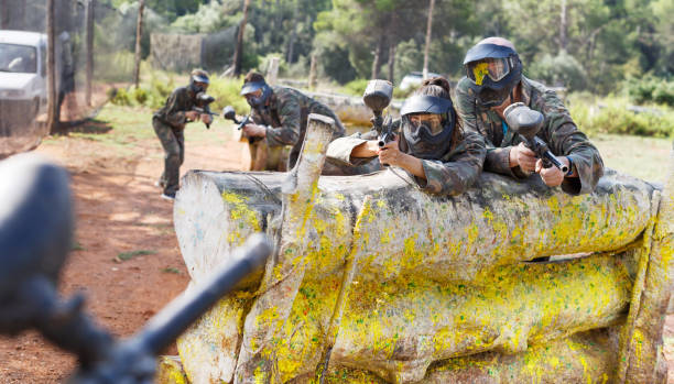 istock Paintball players aiming and shooting with guns 1194718446