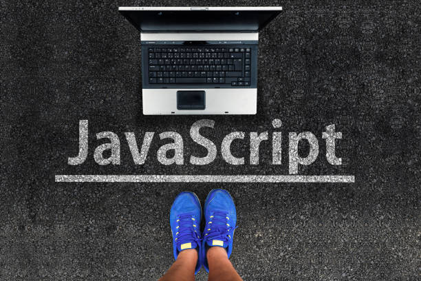 man legs in sneakers standing next to laptop and javascript on asphalt javascrip programming language javascript stock pictures, royalty-free photos & images