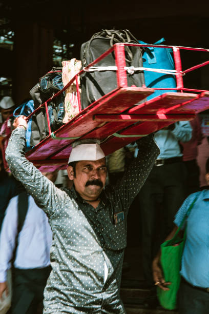Mumbai, India, 18 november, 2019 / Dabbawala lunchbox delivery service: operators with typical whitehat delivering lunchboxes with warm homemade food