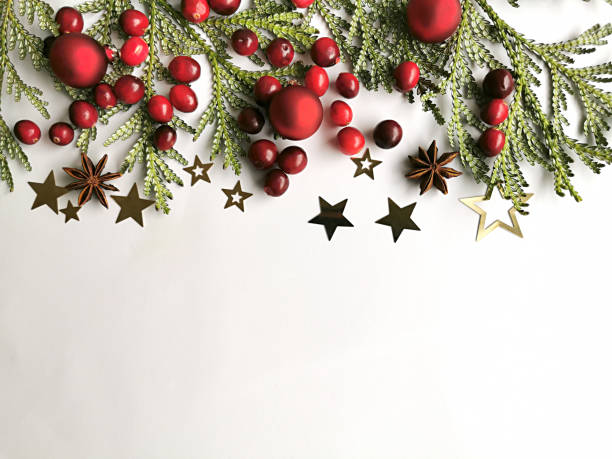 istock Fir branch, red berries and golden stars on a white. 1194721139