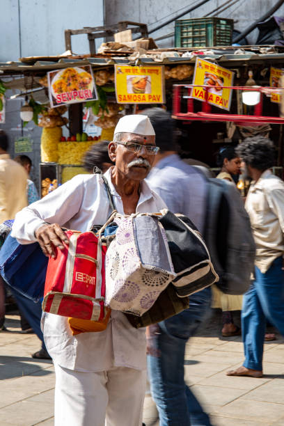 Mumbai, India, 18 november, 2019 / Dabbawala lunchbox delivery service: operators with typical whitehat delivering lunchboxes with warm homemade food