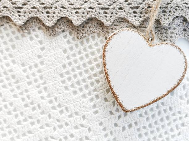 istock Single heart shaped wooden decorations on a white knitted background. 1194721170