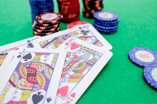 istock Stack of poker chips and cards on a green game table 1194721719