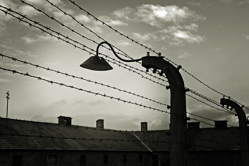 Streetlight on the electrified fence and barracks of the prisoners of the concentration camp.