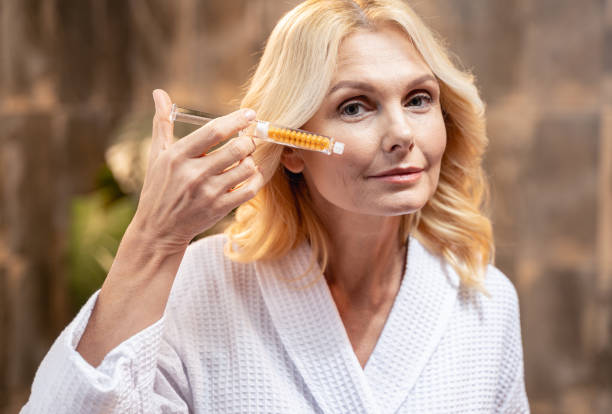istock Lady in a bathrobe showing a cosmetic tool 1194722170