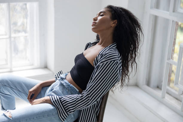 istock Young lady in striped shirt having rest at home 1194724178