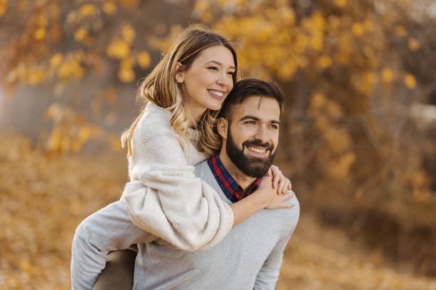 istock Playful couple having fun while piggybacking in autumn day 1194727345