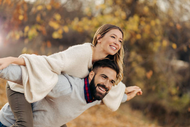 istock Playful couple having fun while piggybacking in autumn day 1194727904