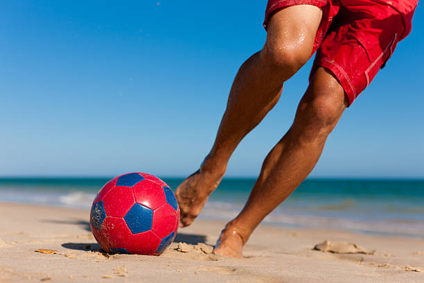 istock Man on the beach kicking soccer ball 119472831