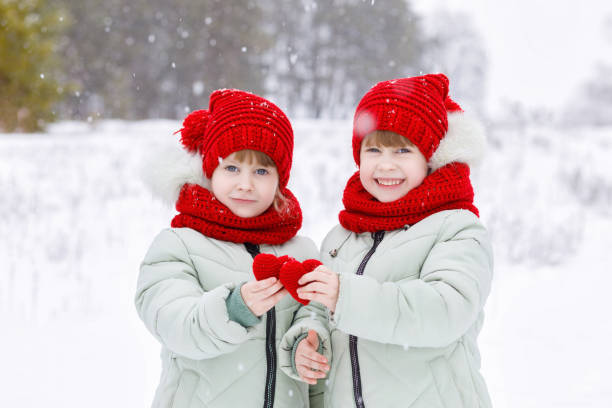 istock Sisters twins are showing two small hearts. 1194730698