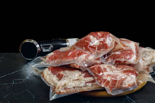 istock Sous vide immersion circulator cooker and the meats Packeds on a dark background . 1194731361