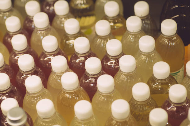 istock Natural fruit drinks in disposable plastic bottles. Plastic bottles on a shop window 1194732122