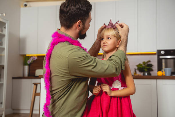 istock Loving father putting crown on daughter head 1194732161