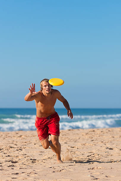 istock Man on the beach playing Frisbee 119473362