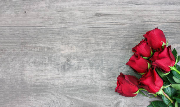 istock Valentine's Day Beautiful Red Roses Bouquet Over Wood Texture Rustic Background 1194735221