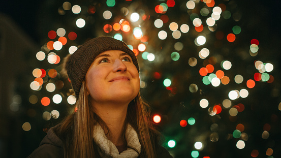 Young Woman Looking up in awe at Christmas Lights