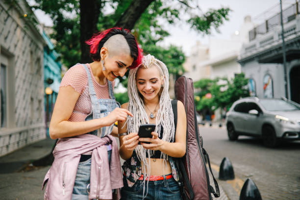 istock Two girls using smartphone in the street 1194737595