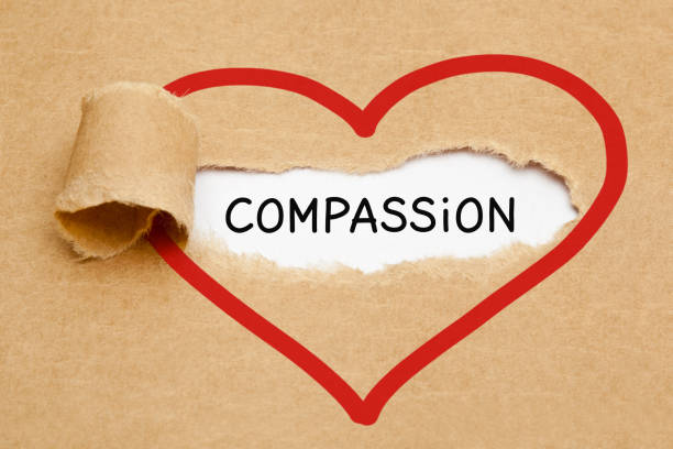 Word Compassion Heart Torn Paper Concept Handwritten word Compassion appearing behind ripped red heart on brown paper. consoling stock pictures, royalty-free photos & images