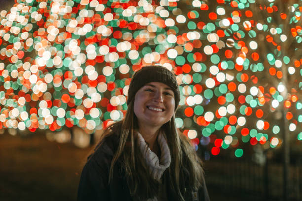 istock Young Woman Smiling with Christmas Lights 1194739030